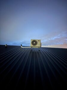 LG airco buitenunit geïnstalleerd op golfplaten dak van woning